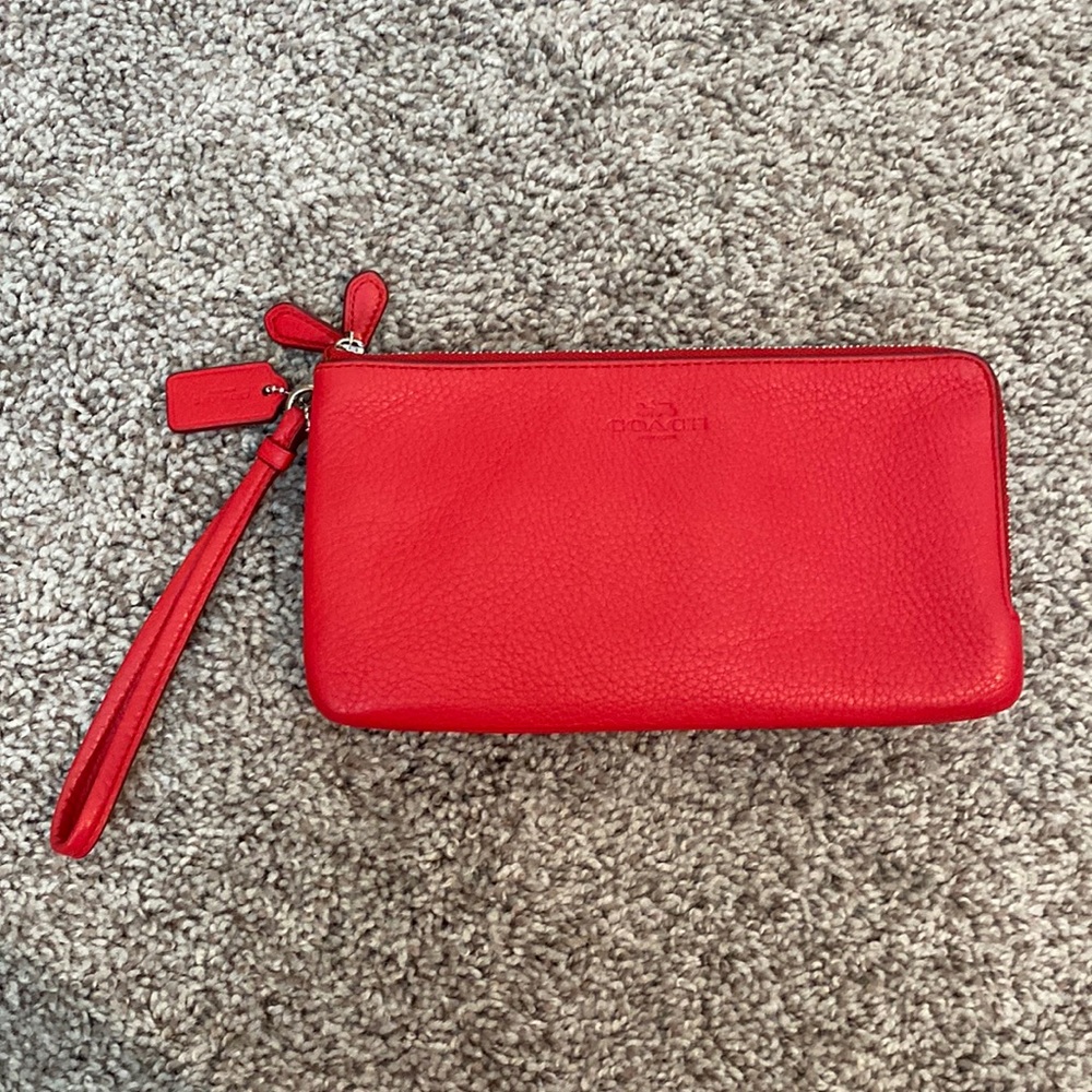 Red Coach wristlet bag with two zipper compartments.